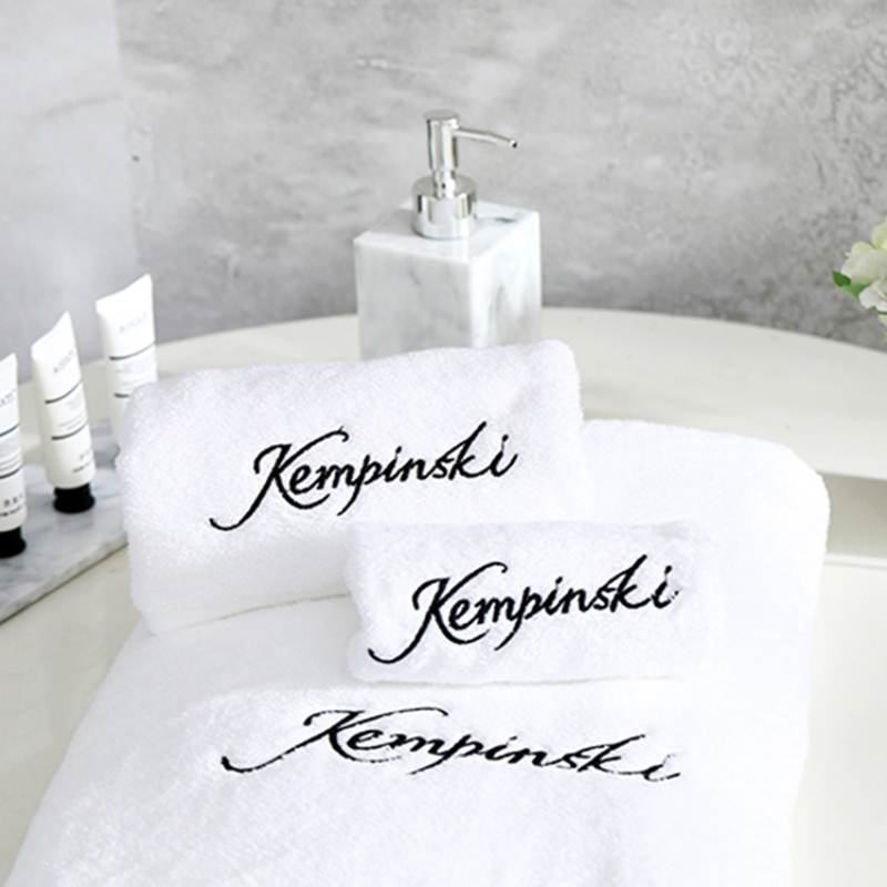 White luxury bath towel set folded neatly on a bathroom shelf